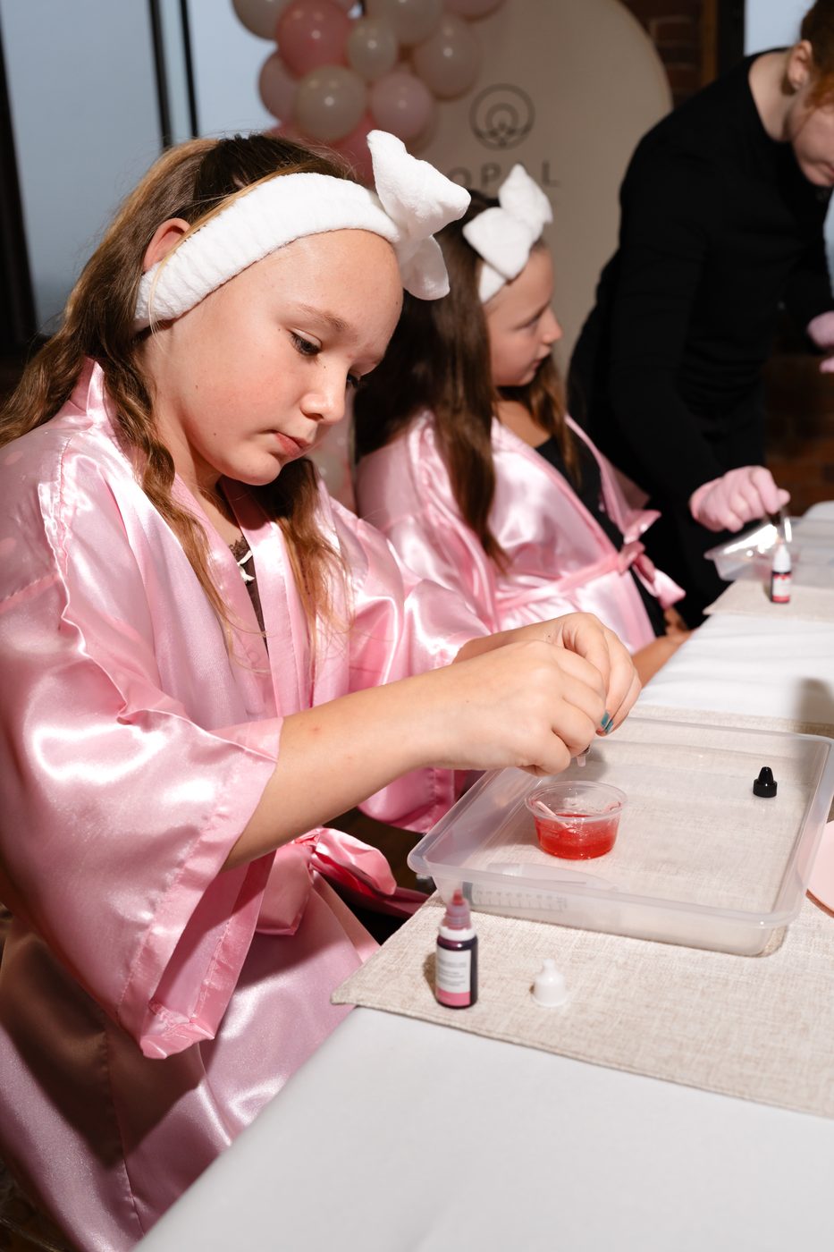 A girl carefully mixing her own take-home sugar scrub at a kids spa birthday party