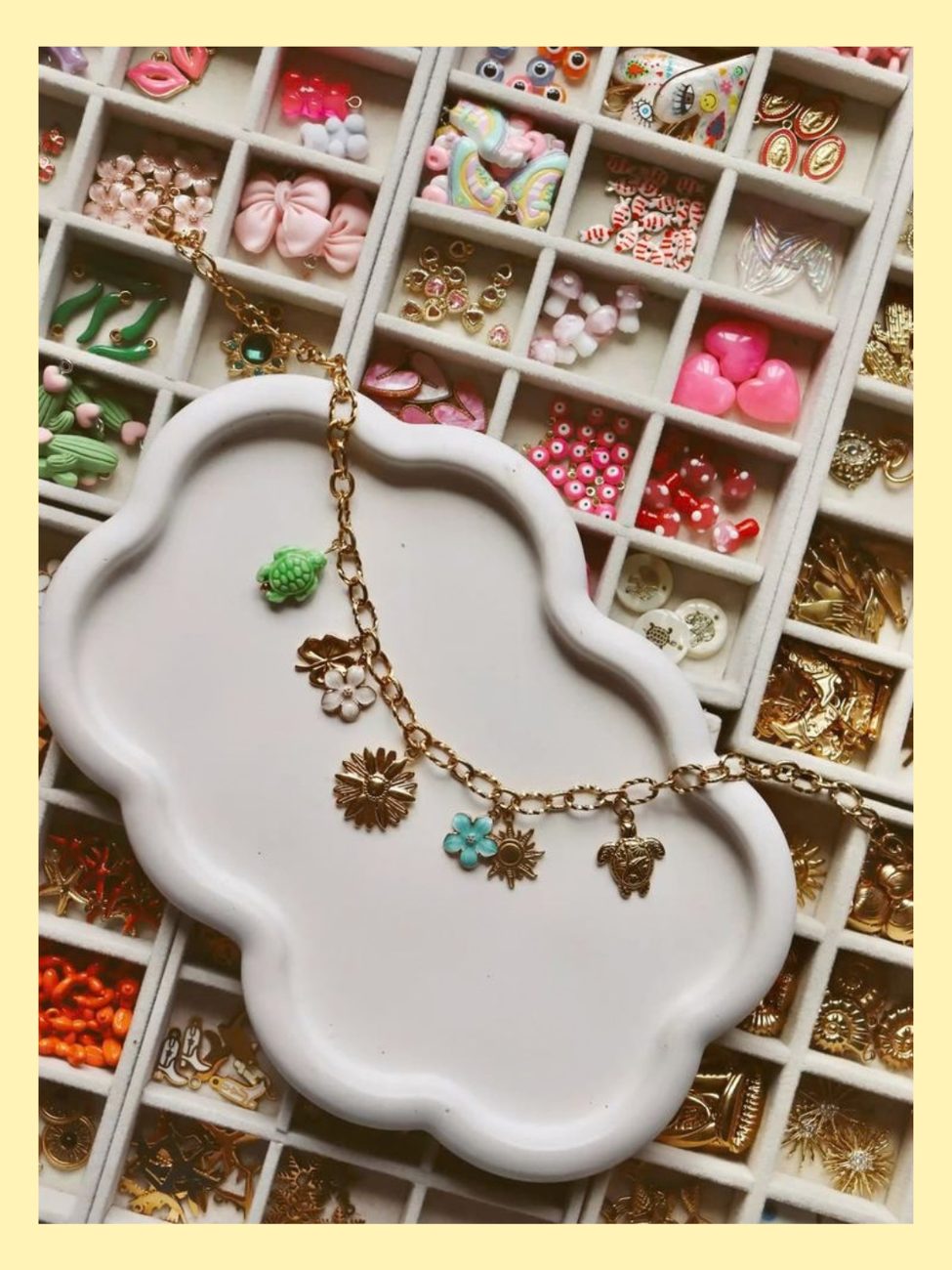 A gold charm bracelet with turtle and flower charms next to a tray of charm options for the Charm Bracelet Bar upgrade